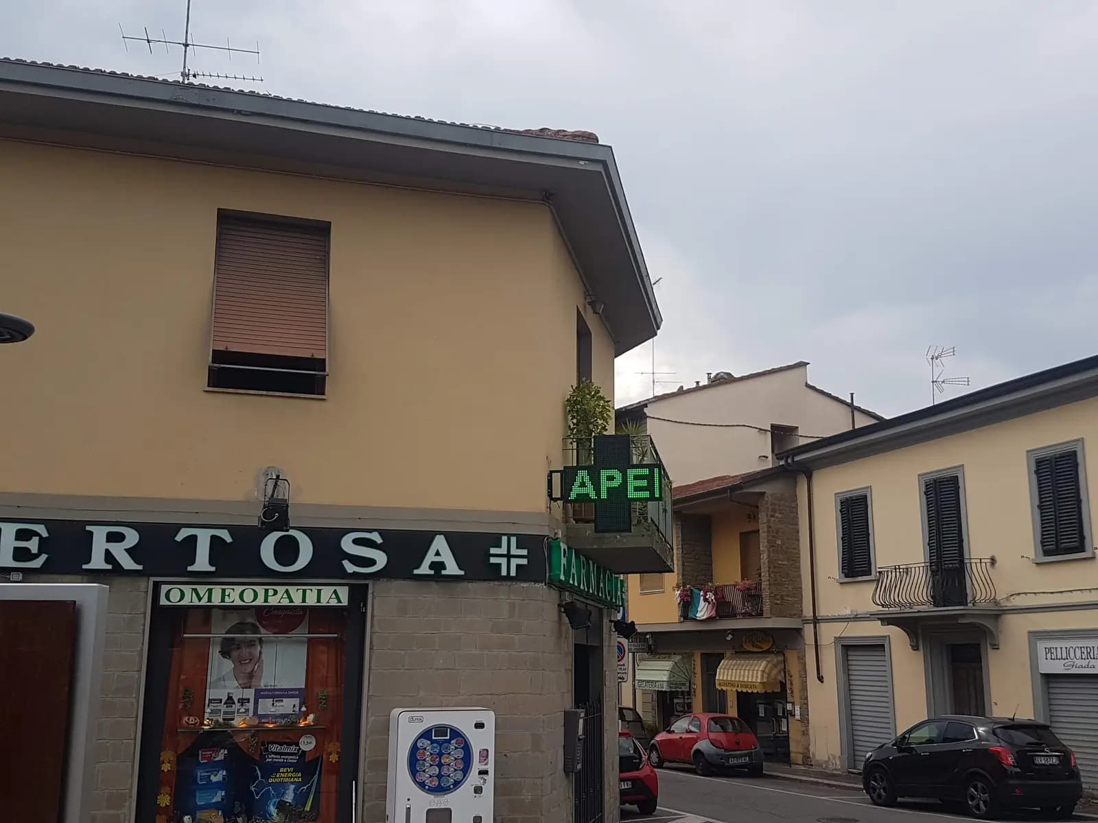 Croce a LED accesa con la scritta APERTO sull’angolo della Farmacia La Certosa a Firenze