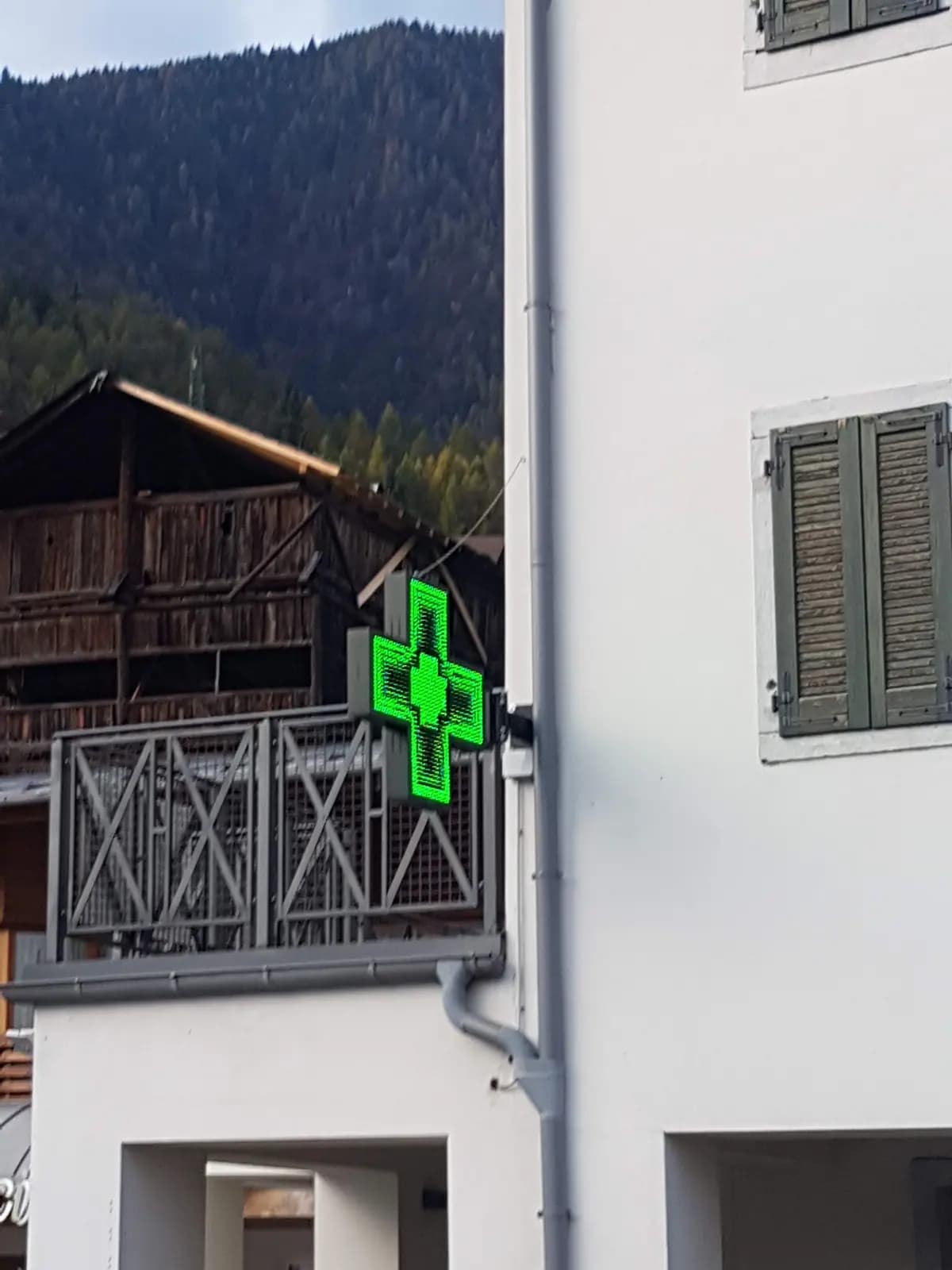 Croce a LED a bandiera che mostra l’ora alla Farmacia Soravia di Valle di Cadore