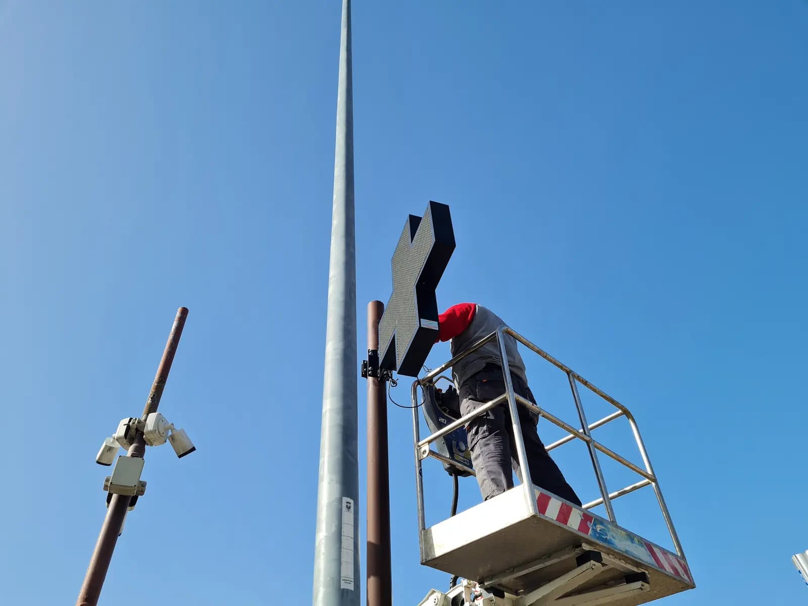 Tecnico Technofusion monta la croce a LED sul palo della Farmacia di Villazzano