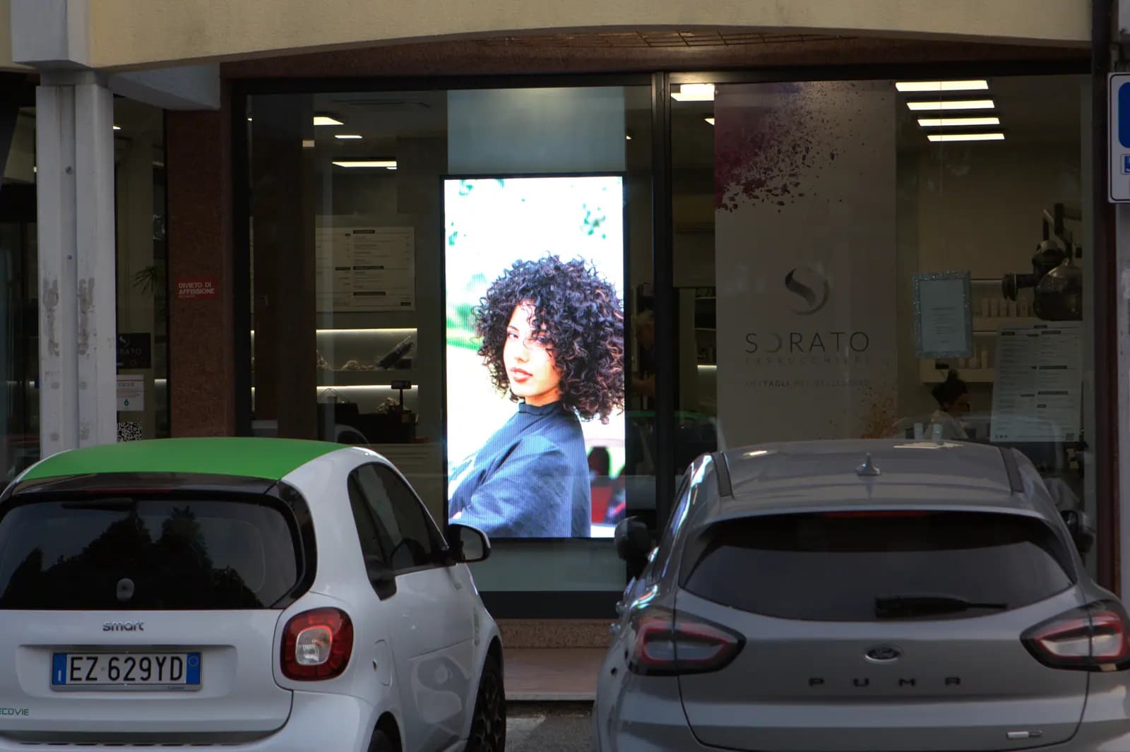 Ledwall verticale acceso nella vetrina di Sorato Parrucchieri