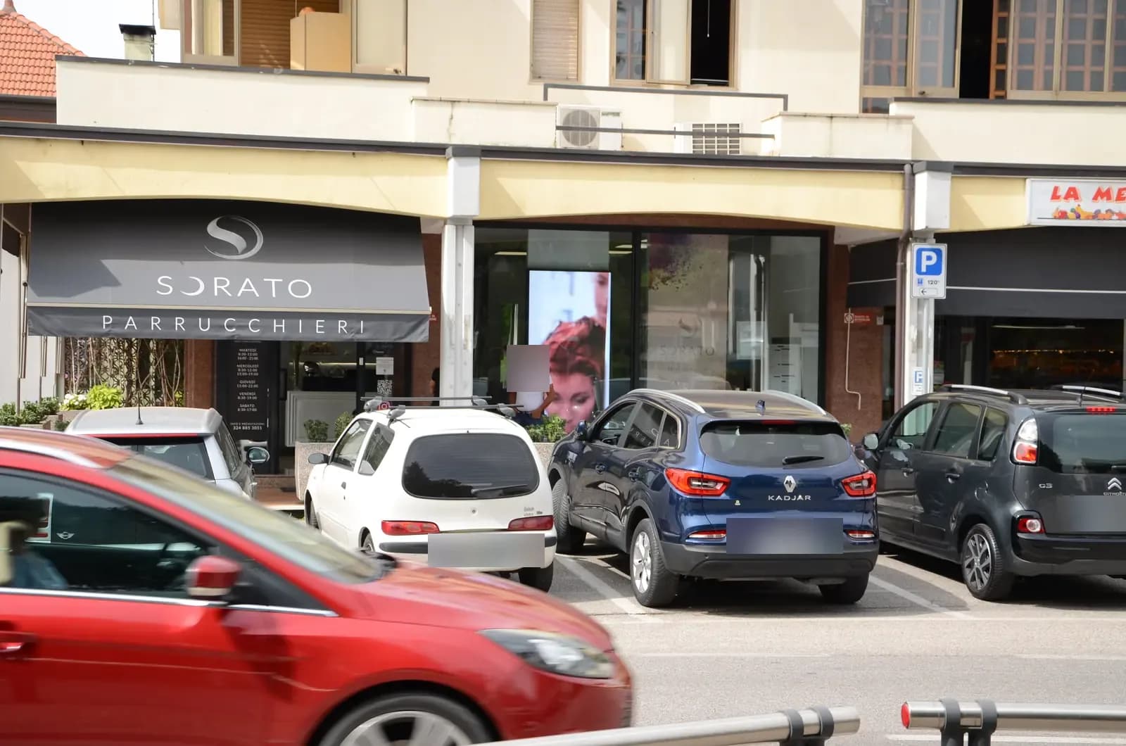 Facciata del salone Sorato Parrucchieri con il ledwall in vetrina