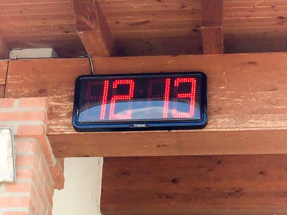 Orologio a LED rosso fissato a una trave in legno